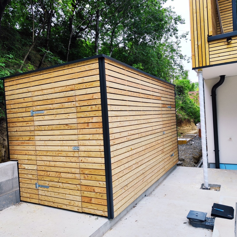 Gartenhütte modern mit Flachdacheindeckung. Fassade passend zum Haus mit Lärche natur unbehandelten Rhombusleisten. Inkl. zwei Holzrahmentüren und ein kleines Fenster für mehr Licht.